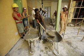 Trabajadores de la construcción laboran en un edificio en La Habana