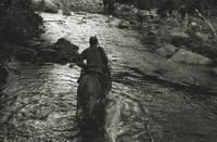 Fidel Castro montado a caballo atraviesa un río en la Sierra Maestra en 1958