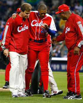Norge Luis Vera es ayudado por el Dr. Antonio Castro, izquierda, tras sufrir calambres, quinto inning del partido contra México, San Diego, 16 de marzo de 2009